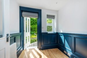 A blue front door, half open letting in natural light. This is in a home in Holland Park, managed by Quintessentially Estates